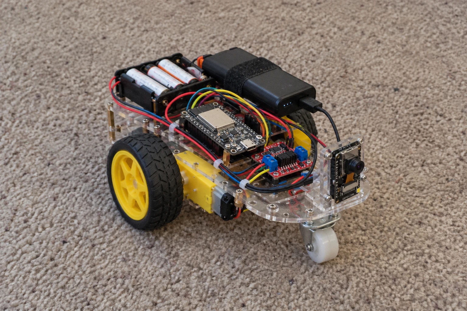 Concept img of pragRover, a small ESP32 rover with a camera, two drive wheels, and exposed electronics.